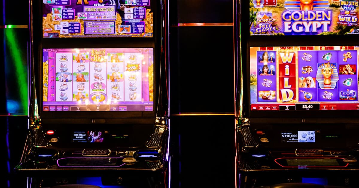 Två upplysta spelautomater på ett kasino med digitala snurrande hjul och vinstlinjer.